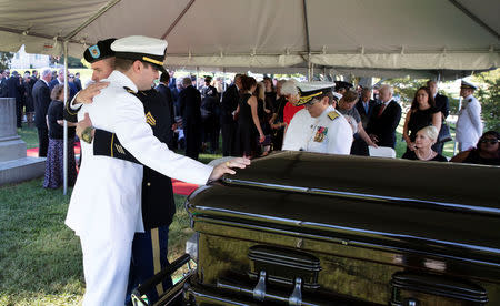 Jimmy McCain hugs his brother Jack McCain (touching casket) as Cindy McCain watches during a burial service for Sen. John McCain, R-Ariz.,at the cemetery at the United States Naval Academy in Annapolis, Md., September 2, 2018. David Hume Kennerly/McCainFamily/Pool via Reuters