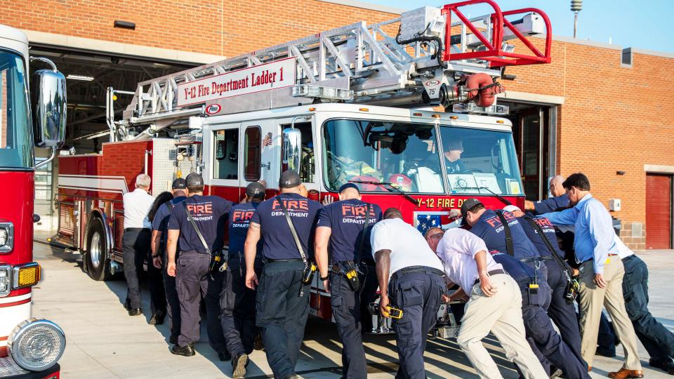 During a push-in ceremony July 24, firefighters and project leaders move Ladder 1 into its new bay at the newly complete Y-12 Fire Station.