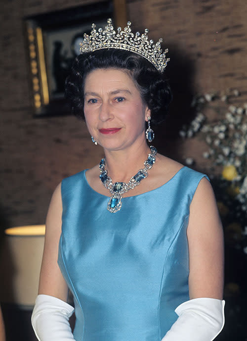 Queen Elizabeth smiled for the camera at the British Embassy reception in Mexico during a state visit in 1975. She was decked out in ice blue jewels to match her shift dress and same elbow-length gloves.