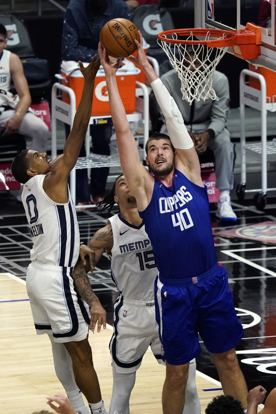Los Angeles Clippers center Ivica Zubac (40) grabs a rebound over Memphis Grizzlies guard De'Anthony Melton (0) during the first half of an NBA basketball game Wednesday, April 21, 2021, in Los Angeles. (AP Photo/Marcio Jose Sanchez)