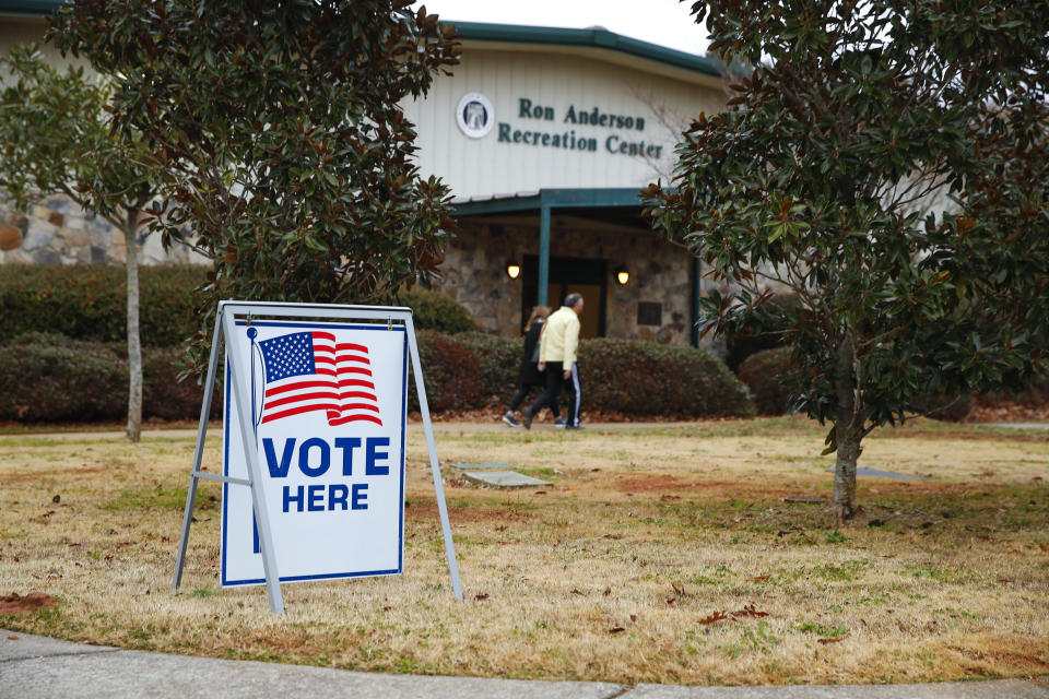 Voters return to their vehicles after early voting for the Senate runoff election, at Ron Anderson Recreation Center, Thursday, Dec. 17, 2020, in Powder Springs, Ga. (AP Photo/Todd Kirkland)