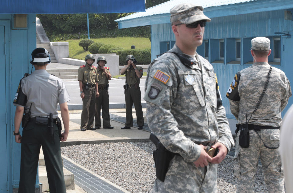 FILE - In this July 27, 2014, file photo, North Korean army soldiers watch the south side while South Korean, left, and U.S. Army soldiers stand guard at the truce villages of Panmunjom in Paju, South Korea. North and South Korea and the U.S.-led United Nations Command on Tuesday, Oct. 16, 2018, are meeting to discuss efforts to disarm a military zone the rivals control within their shared border under a peace agreement between the Koreas. (AP Photo/Ahn Young-joon, File)