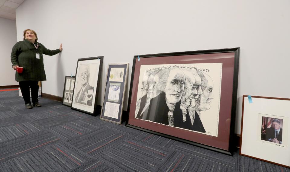 State & Federal Communications President & CEO Elizabeth Bartz talks about some of the political artwork that will hand on the walls of her new 27,000-square-foot office Tuesday in Akron.