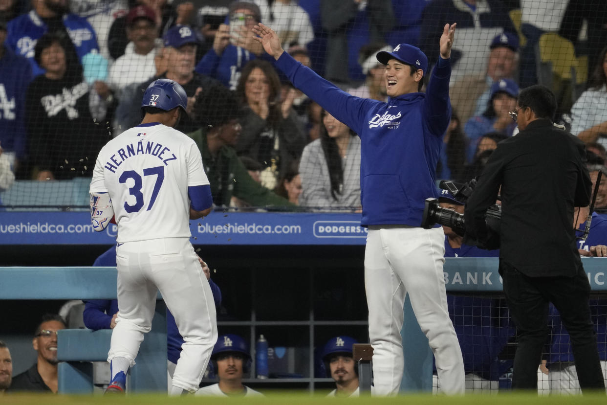 Los Angeles Dodgers' Teoscar Hernández (37) celebrates with designated hitter Shohei Ohtani after hitting a home run during the sixth inning of a baseball game against the Colorado Rockies in Los Angeles, Friday, Sept. 20, 2024. (AP Photo/Ashley Landis)