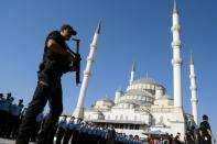 An armed Turkish police officer stands guard during a funeral ceremony for victims of the failed July 15 coup attempt, in Ankara on July 17, 2016