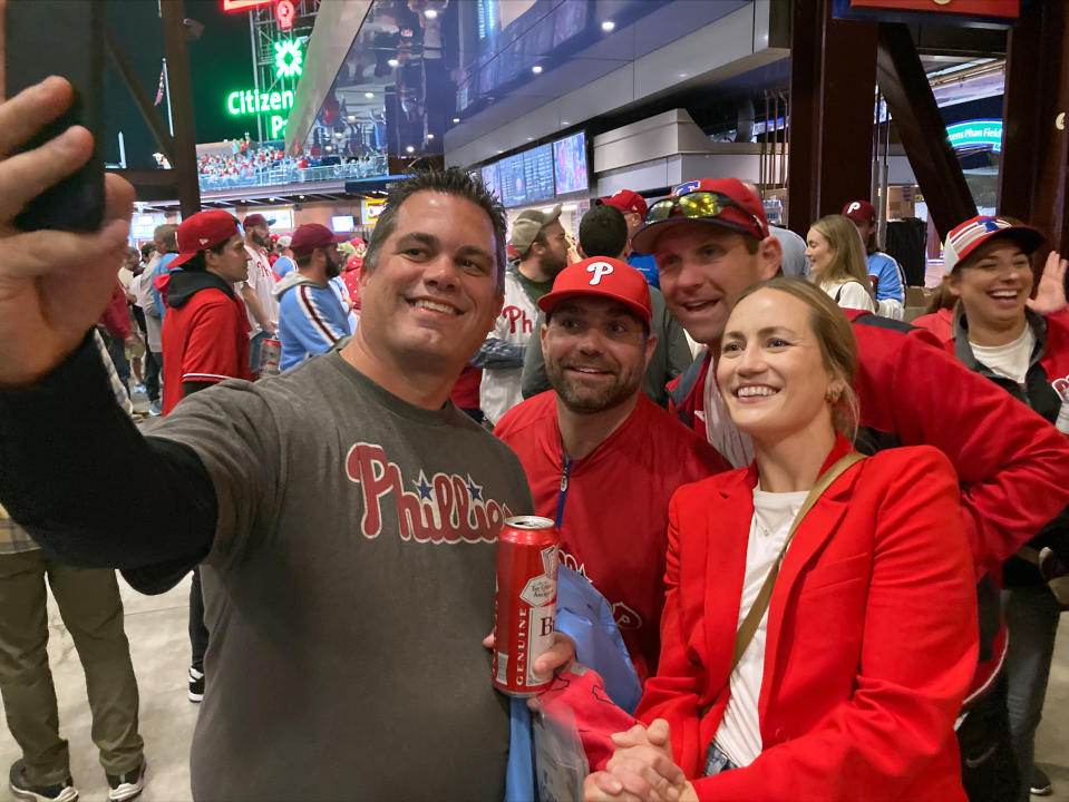 Jayme Hoskins, right, wife of Philadelphia Phillies first baseman Rhys Hoskins, poses with fans at Game 4 of the baseball World Series between the Phillies and the Houston Astros on Wednesday. Nov. 2, 2022, in Philadelphia. Hoskins tweeted she would buy fans beer before the game at Section 104 of the stadium. She paid for about 100 beers. (AP Photo/Daniel Gelston)