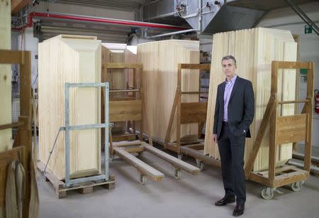 Coffin maker Michael Jagdt (CEO of lignotech Massivholz GmbH) stands in front of coffins in Berlin, December 1, 2014.REUTERS/Axel Schmidt