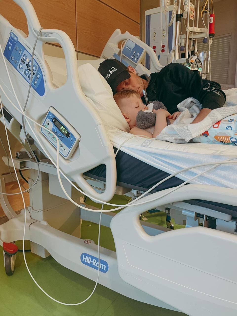 Three-year-old Zeke Clark and father Jonathan Clark share a moment in a hospital bed.