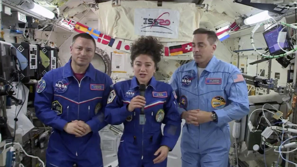 In this image from video made available by NASA, U.S. astronaut Jessica Meir speaks, accompanied by Andrew Morgan and Chris Cassidy, during a news conference held by the American members of the International Space Station on Friday, April 10, 2020. Meir and Morgan said they expect it will be tough returning to such a drastically changed world next week, after a half-year or more in space. (NASA via AP)