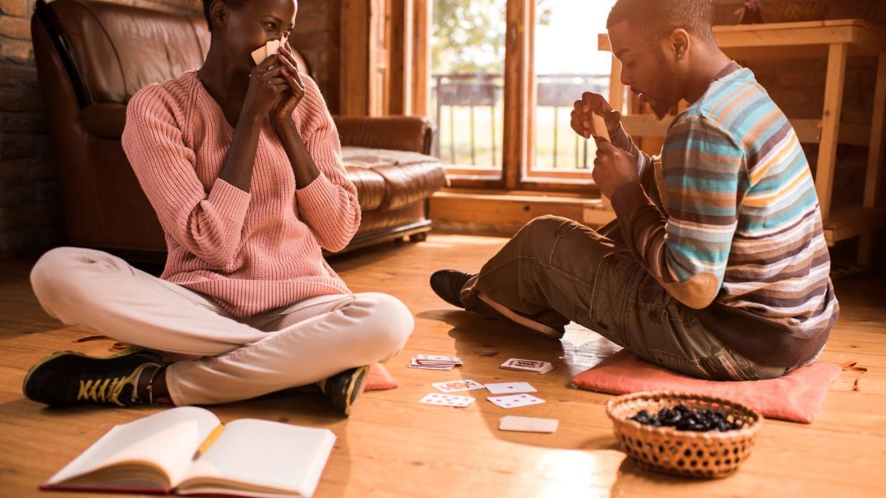 couple having fun while playing cards at home