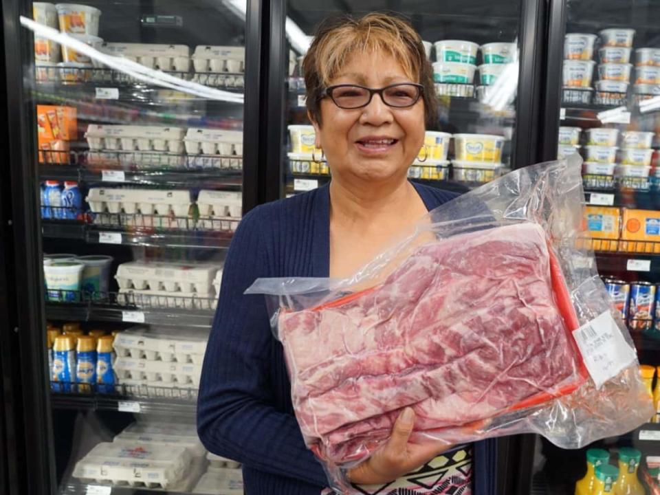 Helen Bighetty couldn't believe she got this package of ribs at Pukatawagan's new grocery store for $16.99 — a bargain compared to what she's used to paying in the northern Manitoba community. (Austin Grabish/CBC - image credit)
