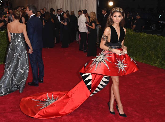 Zendaya in a custom gown with a black bodice and red skirt with silver accents on a gala event