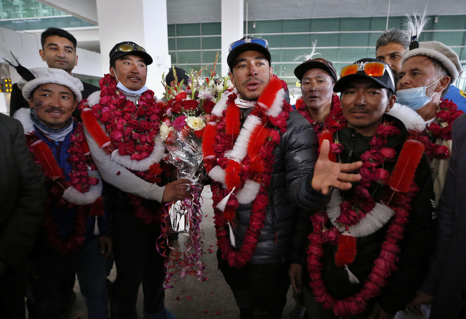 Nepalese climber Nirmal Purja, center, and his team, who recently made history by scaling the K2 summit in the winter season, are greeted by local tour operators upon their arrival at airport in Islamabad, Pakistan, Thursday, Jan. 21, 2021. Winter winds on K2 can blow at more than 200 km per hour (125 miles per hour) and temperatures can drop to minus 60 C (minus 76 F), an official of Pakistan's Alpine Club, Karrar Haideri said. (AP Photo/Anjum Naveed)