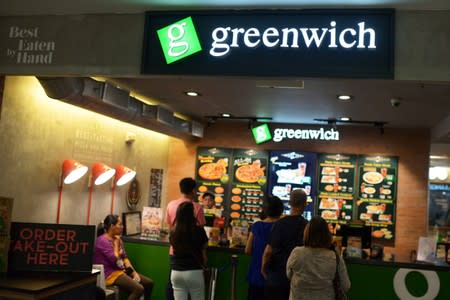 Customers line up at a branch of Greenwich in Manila