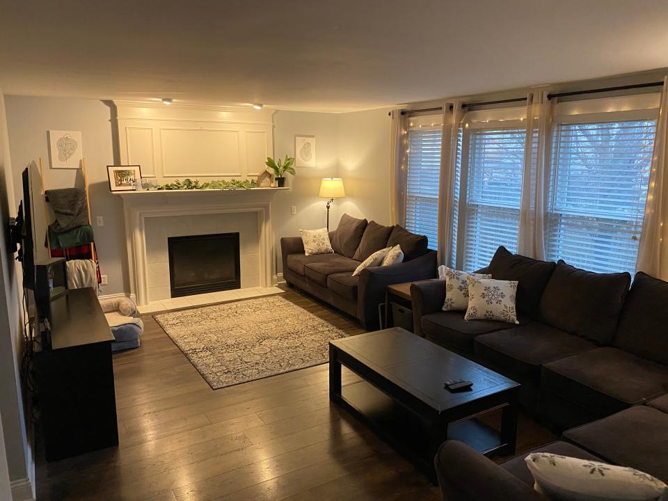 living room with light walls, fireplace and dark coach