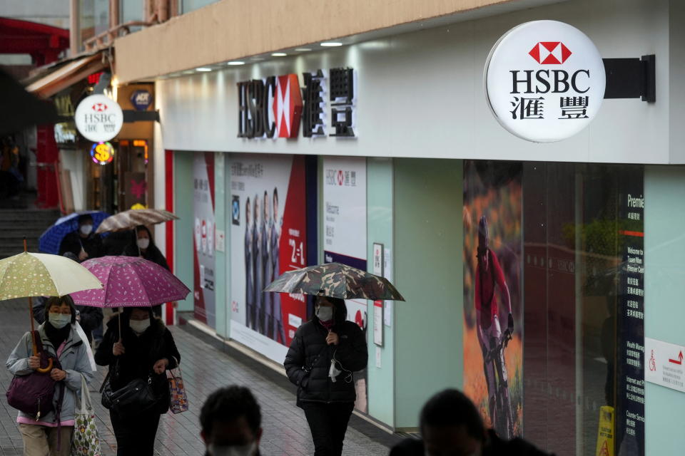 Pedestrians wearing face masks following the coronavirus disease (COVID-19) outbreak, walk past a HSBC bank branch in Hong Kong, China February 22, 2022. REUTERS/Lam Yik