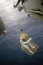 In this April 17, 1970 photo made available by NASA, astronaut Jim Lovell, commander, is hoisted aboard a helicopter from the USS Iwo Jima, after splashdown of the Apollo 13 command module in the Pacific Ocean. (NASA via AP)