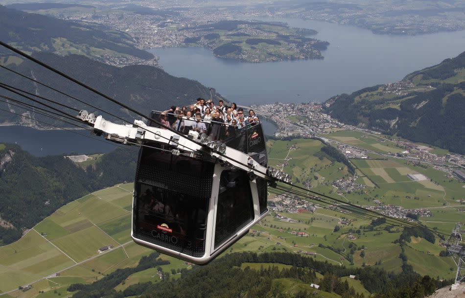 People ride on the inauguration trip of the world's first open-air double-decker cable car system, the newly-built "Cabrio", on the Stanserhorn Mountain, near Lucerne.