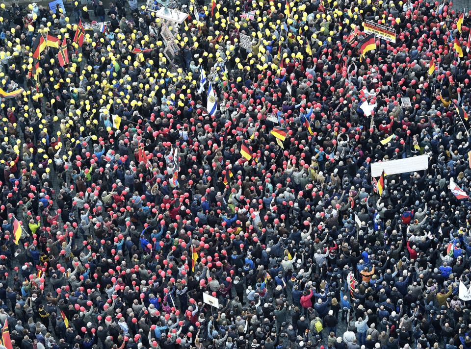 People hold balloons in the colors of the German national flag during a rally of PEGIDA (Patriotic Europeans against the Islamization of the West) in Dresden, Germany, Sunday, Oct.21, 2018. (AP Photo/Jens Meyer)