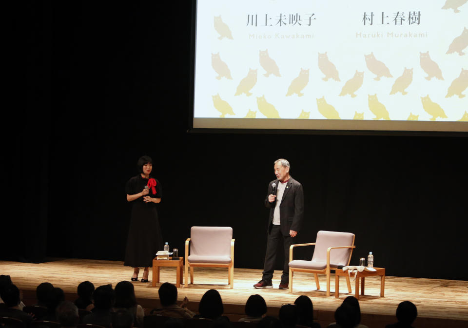 In this photo provided by Shinchosa, author Haruki Murakami, right, speaks on stage next to author Mieko Kawakami in Tokyo, Tuesday, Dec. 17, 2019. A monkey that confesses he steals women's identity cards, causing them to temporarily forget who they are, stars as author Haruki Murakami marks 40 years since his debut as a novelist with his first public reading in Japan in nearly a quarter century. Now 70 and one of the world’s most popular and acclaimed novelists, Murakami debuted with “Hear the Wind Sing” in 1979, four years after he began writing while running a jazz bar in Tokyo. (Shinchosa via AP)