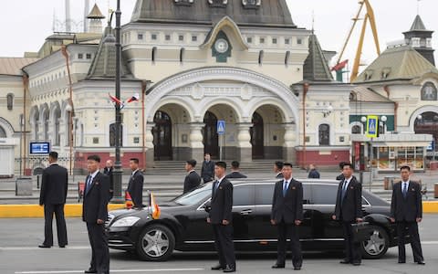 Bodyguards surround Kim's limousine - Credit: Kirill KUDRYAVTSEV/AFP
