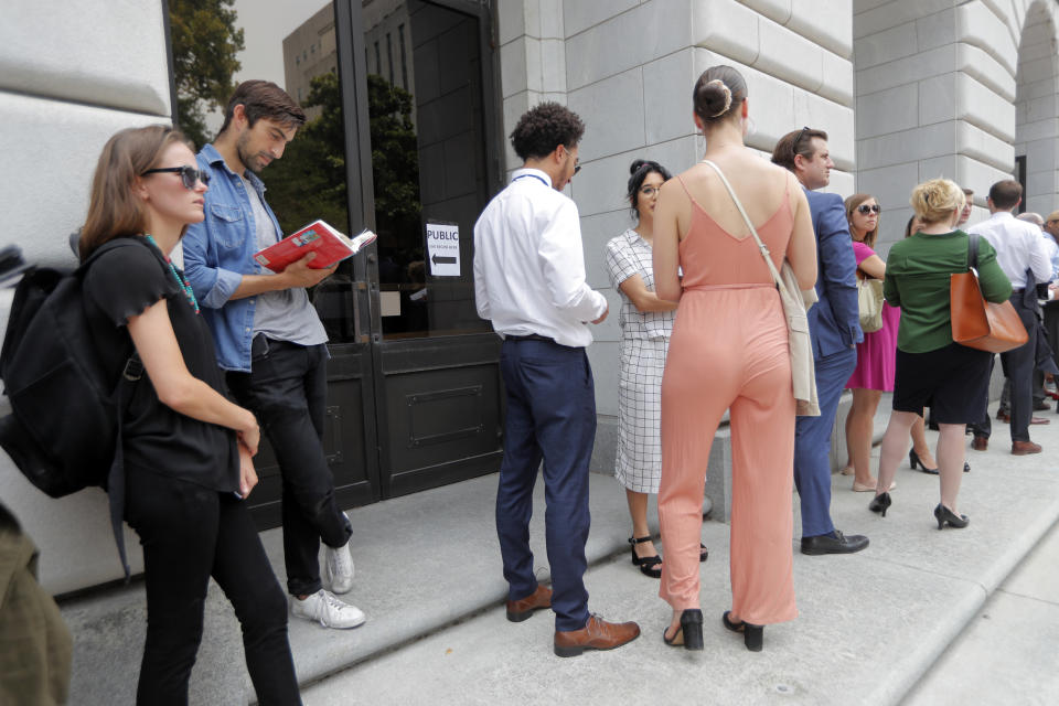 People wait in line to enter the 5th Circuit Court of Appeals to sit in overflow rooms to hear arguments in New Orleans, Tuesday, July 9, 2019. The appeals court will hear arguments today on whether Congress effectively invalidated former President Barack Obama's entire signature health care law when it zeroed out the tax imposed on those who chose not to buy insurance. A Texas judge in December ruled it was invalid, setting off an appeal by states who support the law. (AP Photo/Gerald Herbert)