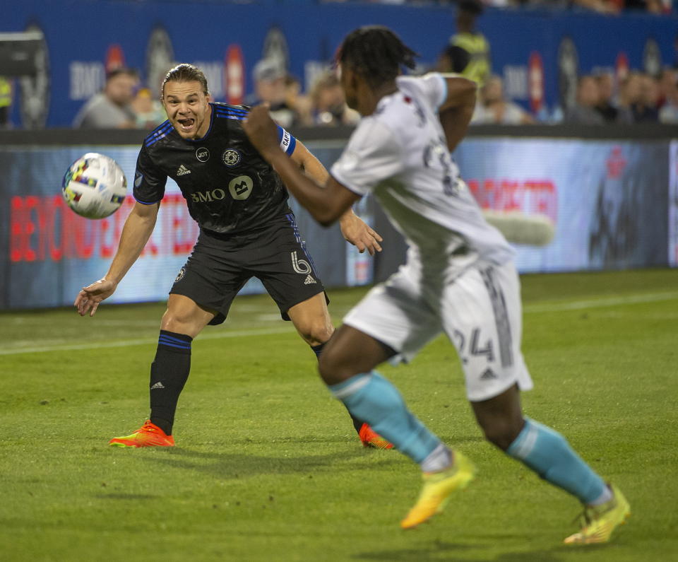 CF Montreal's Samuel Piette, left, eyes a pass as New England Revolution's DeJuan Jones takes a position to block it during first-half MLS soccer match action in Montreal, Saturday, Aug. 20, 2022. (Peter McCabe/The Canadian Press via AP)