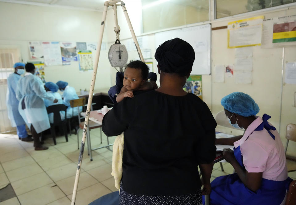 A mother waits for her baby to be vaccinated against measles at a clinic in Harare, Wednesday, Sept. 14, 2022. Church members in Zimbabwe are getting their children vaccinated against measles in secret amid a deadly outbreak. It's to avoid being shunned by religious leaders who are opposed to modern medicine. (AP Photo/Tsvangirayi Mukwazhi)