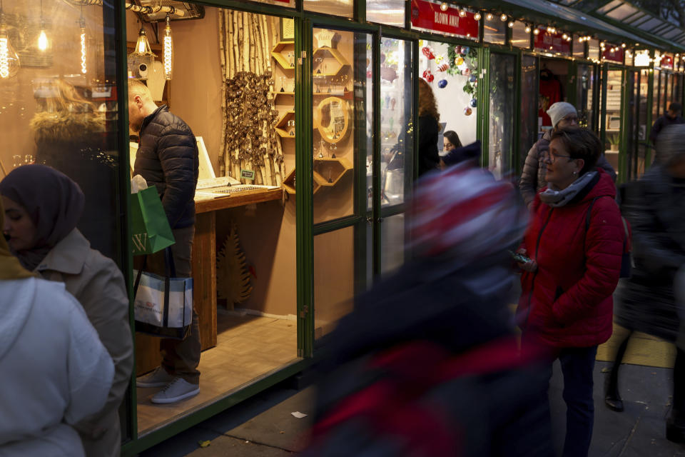 People browse shops in Bryant Park's Winter Village, Tuesday, Nov. 15, 2022, in New York. After two years of pandemic holidays when people spent more dollars online, shoppers are back in force in stores and at holiday markets. Small businesses say it is beginning to feel a lot like Christmas, both emotionally and financially. (AP Photo/Julia Nikhinson)