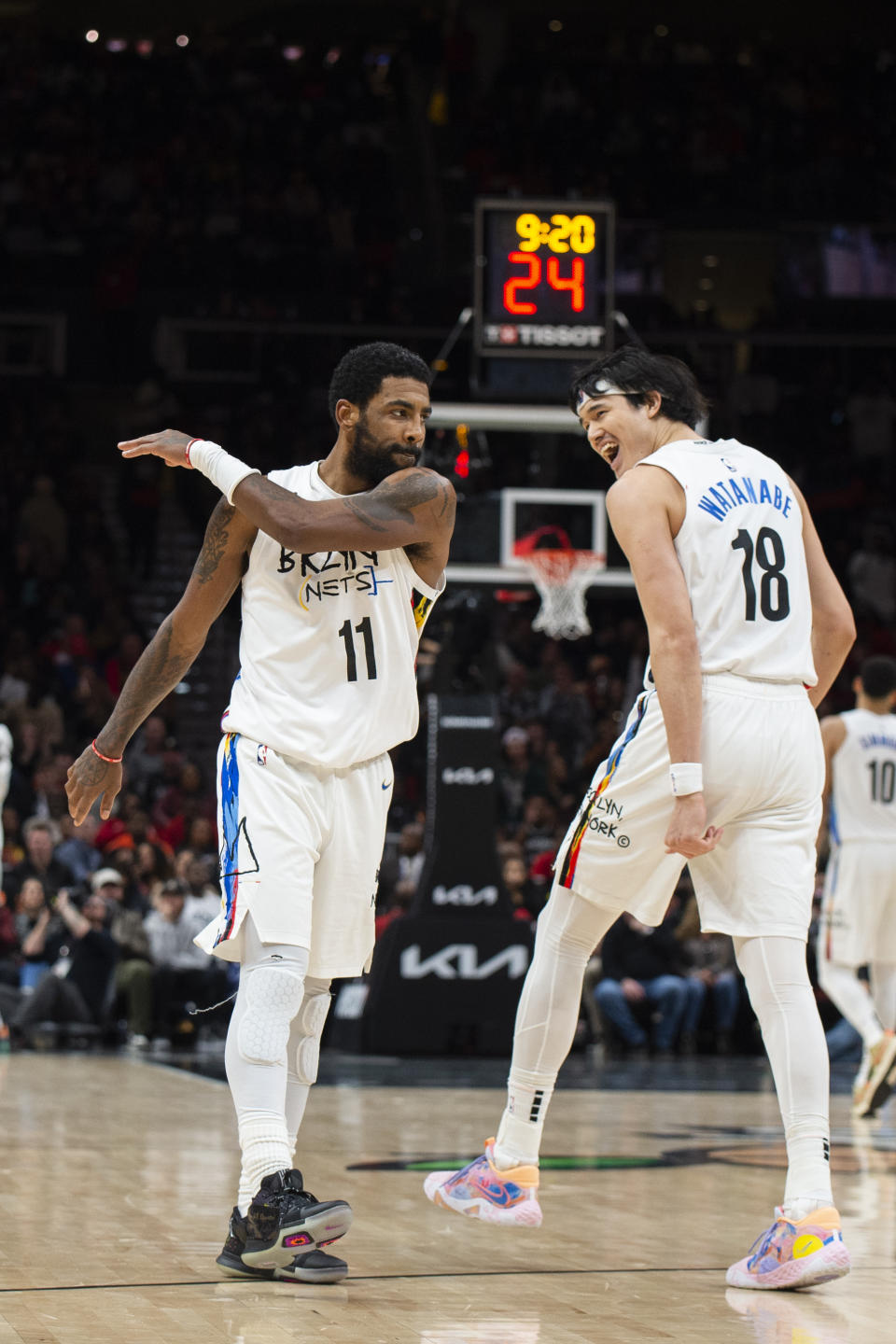 Brooklyn Nets guard Kyrie Irving (11) and Brooklyn Nets forward Yuta Watanabe (18) react after scoring during the second half of an NBA basketball game against the Atlanta Hawks, Wednesday, Dec. 28, 2022, in Atlanta. (AP Photo/Hakim Wright Sr.)