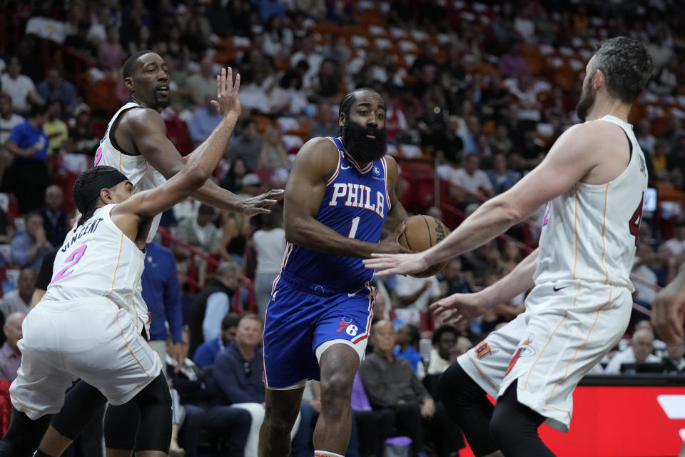 Philadelphia 76ers guard James Harden (1) drives to the basket against Miami Heat center Bam Adebayo, left rear, guard Gabe Vincent (2) and forward Kevin Love, right, during the first half of an NBA basketball game, Wednesday, March 1, 2023, in Miami. (AP Photo/Wilfredo Lee)