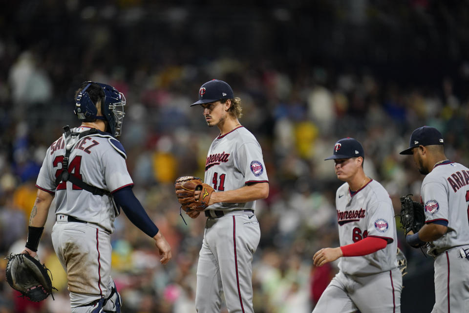 Minnesota Twins starting pitcher Joe Ryan, center, looks on before exiting during the fifth inning of a baseball game against the San Diego Padres, Friday, July 29, 2022, in San Diego. (AP Photo/Gregory Bull)