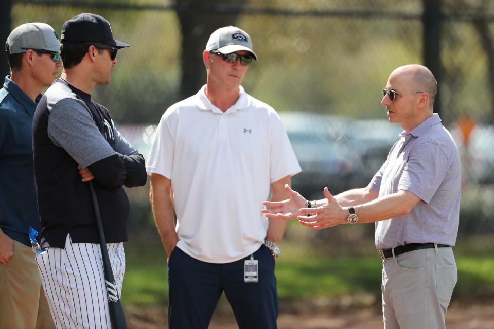 Feb 20, 2018; Tampa, FL, USA; New York Yankees manager Aaron Boone (17) talks with general manager Brian Cashman and vice president of baseball operations Tim Naehring during spring training at George M. Steinbrenner Field. Mandatory Credit: Kim Klement-USA TODAY Sports