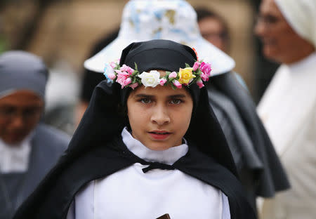 A young woman dressed as St Rosa of Lima, patron saint of Peru, waits for Pope Francis to arrive at the nunciature, in Lima, Peru January 18, 2018. REUTERS/Guadalupe Pardo