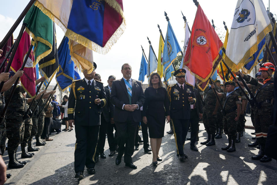 El presidente Bernardo Arévalo, en el centro a la izquierda, y su vicepresidenta, Karin Herrera, llegan a una ceremonia con el Ejército en la plaza de la Constitución en Ciudad de Guatemala, el lunes 15 de enero de 2024, en la mañana posterior a su investidura. (AP Foto/Moisés Castillo)