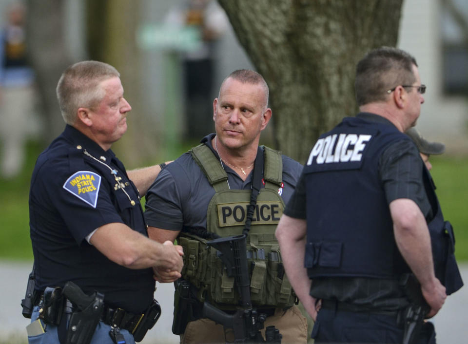 Indiana State Police Sgt. Joe Watts, left, consoles Terre Haute Chief of Police John Plasse, centre, at the scene of the fatal shooting. Source: AP