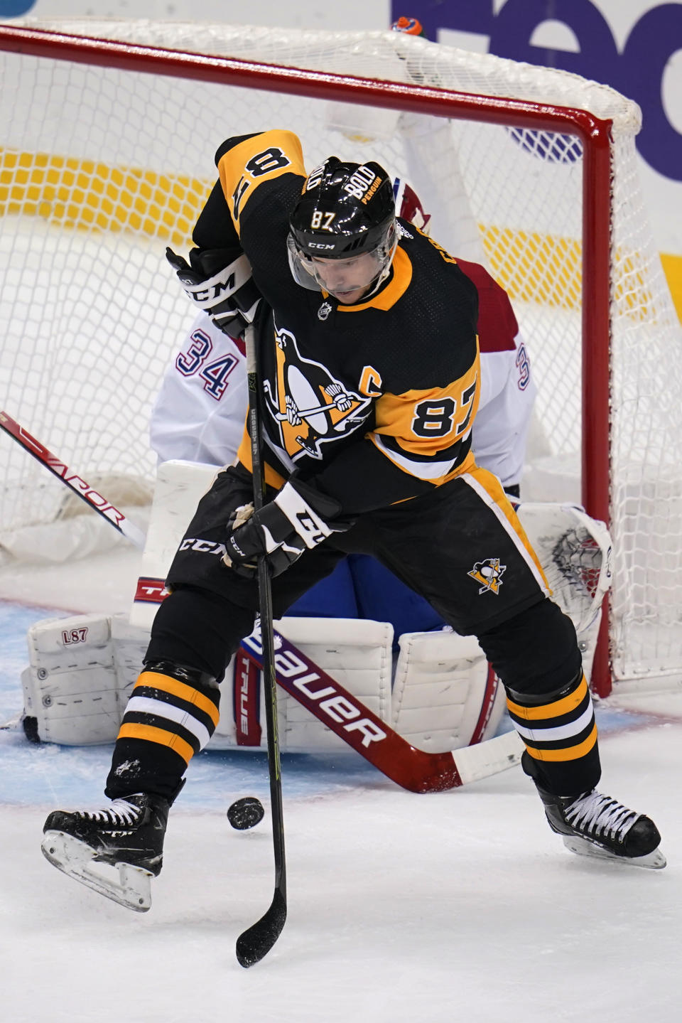 Pittsburgh Penguins' Sidney Crosby (87) redirects a shot in front of Montreal Canadiens goaltender Jake Allen (34) during the period of an NHL hockey game in Pittsburgh, Saturday, Nov. 27, 2021. (AP Photo/Gene J. Puskar)