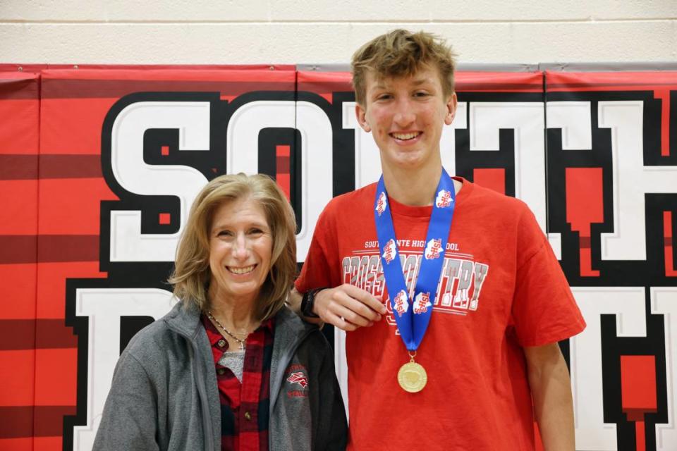 South Pointe High School cross-country runner Garrett Brown stands with coach Trish Sacco at the school Wednesday.