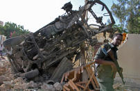 <p>A Somali soldier stands near the wreckage from a car bomb blast and gun battle targeting a restaurant in Mogadishu, Somalia, Thursday, June 15, 2017. (Photo: Farah Abdi Warsameh/AP) </p>