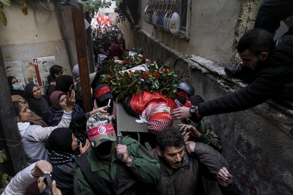 Mourners carry the body of 15-year-old Palestinian Adam Ayyad during his funeral in the West Bank city of Bethlehem, Tuesday, Jan. 3, 2023. The Palestinian Health Ministry said Ayyad died of a bullet wound to the chest. The Israeli military said Border Police officers came under attack in the Dheisha refugee camp next to Bethlehem. It said troops shot at people throwing firebombs and confirmed that a person was shot. (AP Photo/Mahmoud Illean)