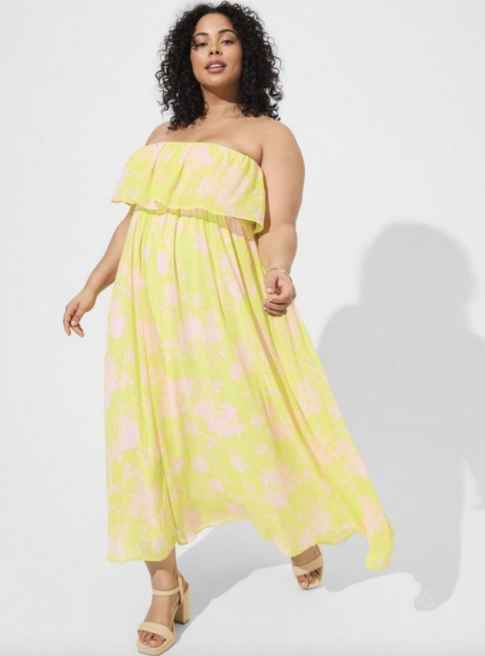 plus size model wearing yellow and light pink Maxi Chiffon Strapless Ruffle Dress (photo via Torrid)