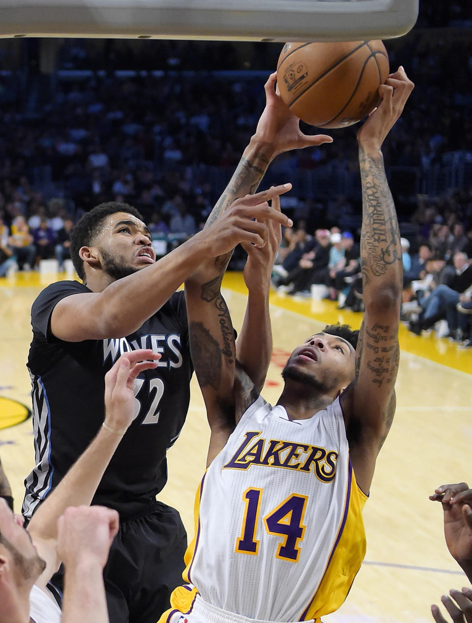 Minnesota Timberwolves center Karl-Anthony Towns, left, and Los Angeles Lakers forward Brandon Ingram reach for a rebound during the first half of an NBA basketball game, Sunday, April 9, 2017, in Los Angeles. (AP Photo/Mark J. Terrill)