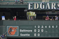 A Seattle Fire Dept. EMT, left, fills a syringe at a clinic administering free COVID-19 vaccines located above the manual scoreboard at T-Mobile Park during a baseball game between the Seattle Mariners and the Baltimore Orioles, Wednesday, May 5, 2021, in Seattle. The Mariners will be offering vaccines to eligible fans during upcoming home games. (AP Photo/Ted S. Warren)