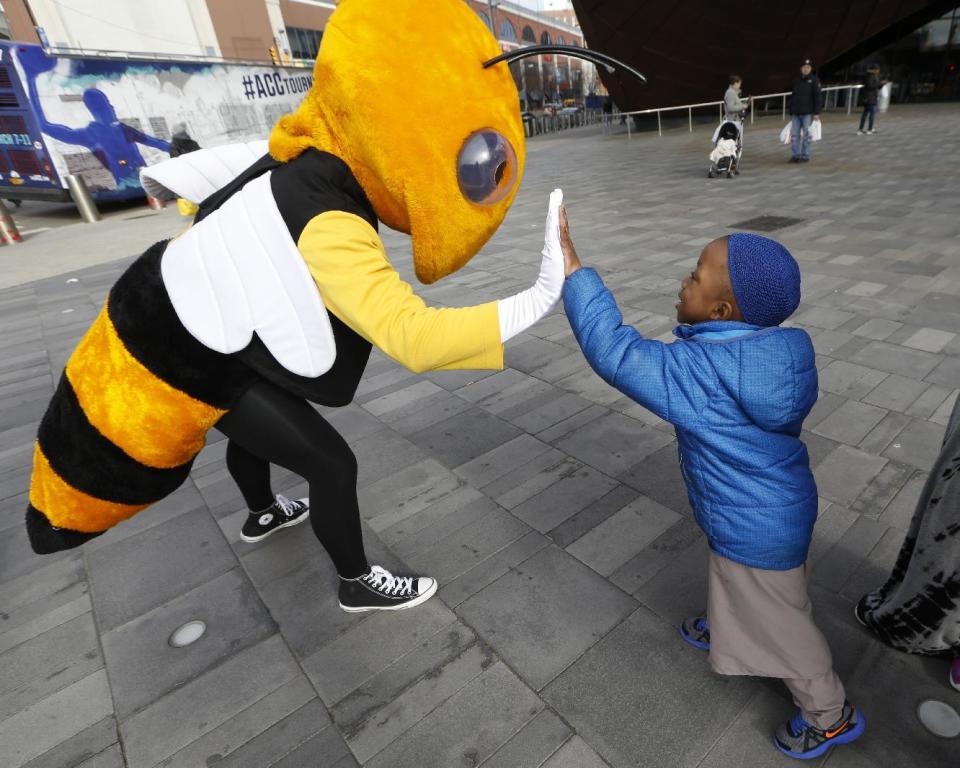 Four year-old Malik McKenna, right, greets "Buzz," the Georgia Tech Yellow Jackets' mascot, outside the Barclays Center, Monday, March 6, 2017, in New York. Buzz and 14 other Atlantic Coast Conference mascots took part in a press conference, rode the subway and walked in Main Street Park in downtown Brooklyn to promote the upcoming ACC basketball tournament March 7-11 at the Barclays Center in Brooklyn. (AP Photo/Kathy Willens)