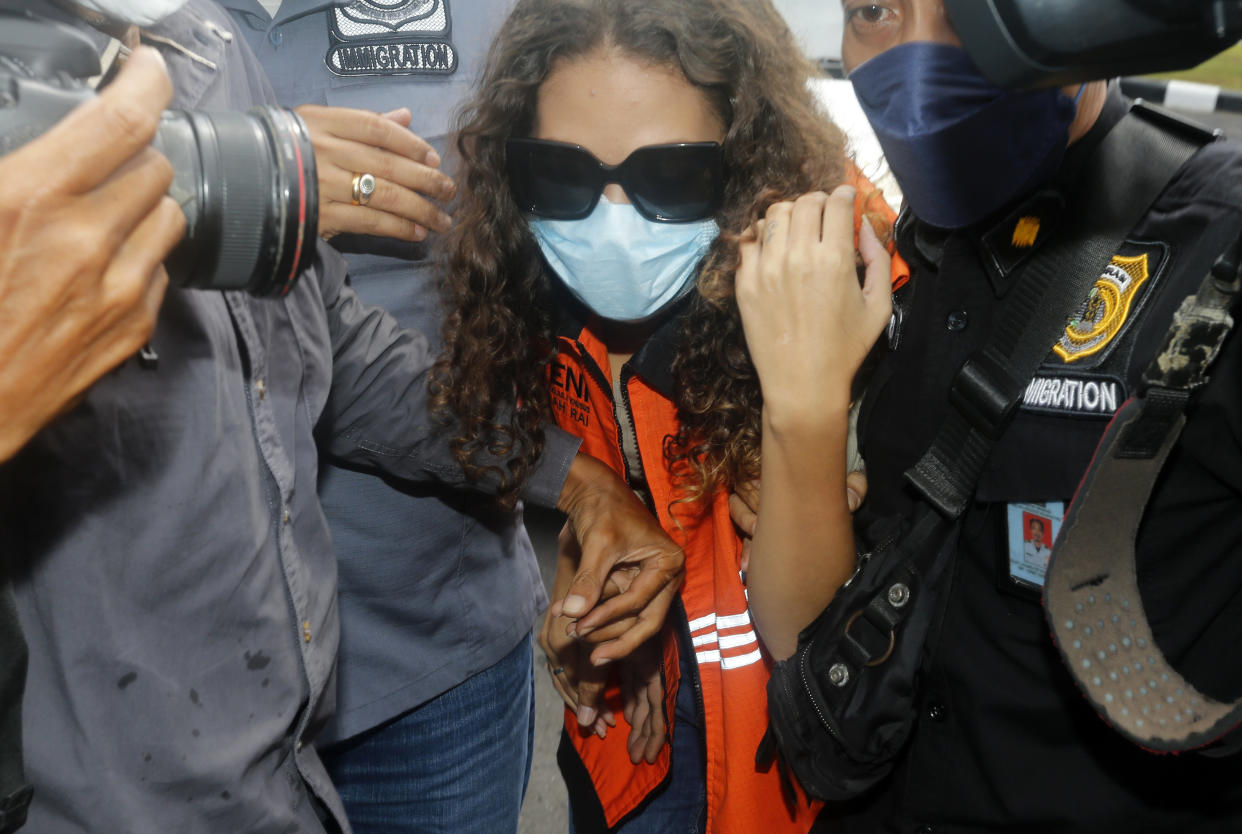 FILE - Heather Mack of Chicago, Ill., center, escorted by immigration officers to Immigration detention center in Jimbaran, Bali, Indonesia on Friday, Oct. 29, 2021. Mack, who served more than seven years in an Indonesian prison for killing her mother at a luxury resort in Bali has been indicted on federal murder conspiracy charges and taken into custody by FBI agents at O'Hare International Airport in Chicago on Wednesday Nov. 3, 2021. (AP Photo/Firdia Lisnawati, File)