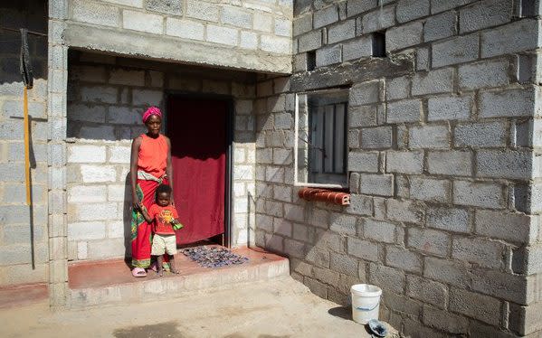 Lillian with one of her 11 children outside the family home on the outskirts of Lusaka