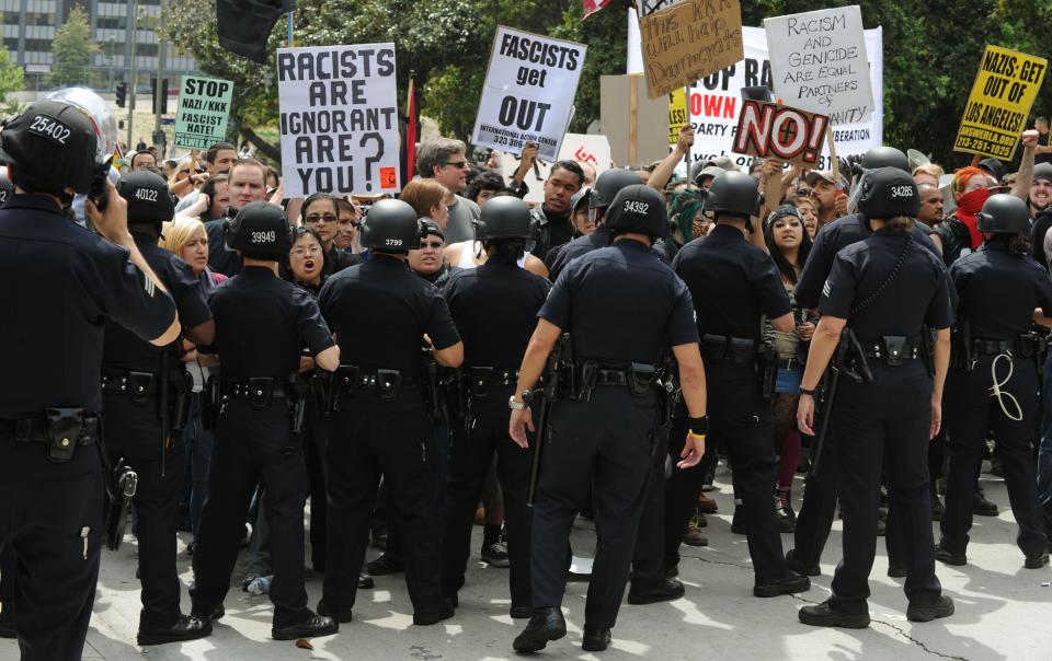 Police block an angry crowd of counterprotesters after the neo-Nazi group the American National Socialist Movement held a rally in front of the Los Angeles City Hall, on April 17, 2010. Police in riot gear formed a line in front of a crowd of about 500 counterprotesters who gathered to protest the white supremacist rally. About 70 members of the group, many wearing black uniforms, attempted to stage a rally but were largely outshouted by counter-protesters.