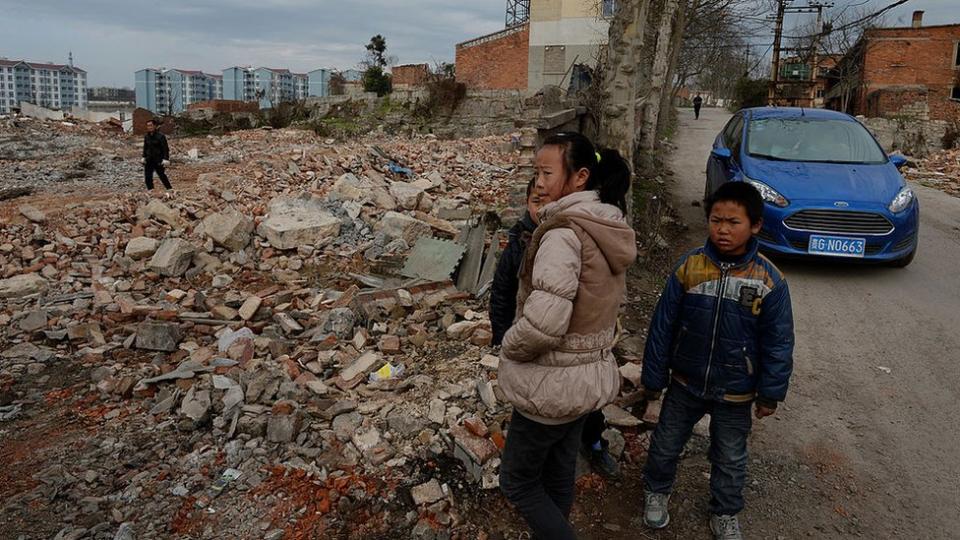 Unos niños observan las construcciones a lo lejos de nuevos edificios en Anshun, provincia de Guizhou, 2014