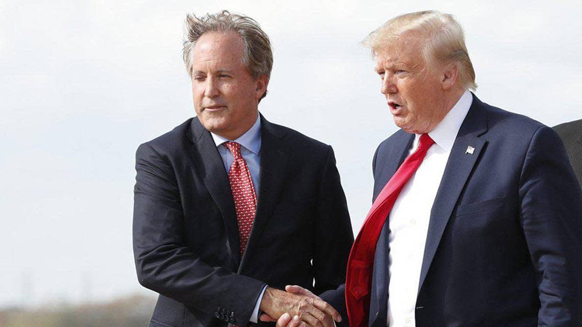 Texas Attorney General Ken Paxton, left, greeting former President Donald Trump, right, at Austin Bergstrom International Airport. (Jay Janner/Austin American-Statesman/TNS)