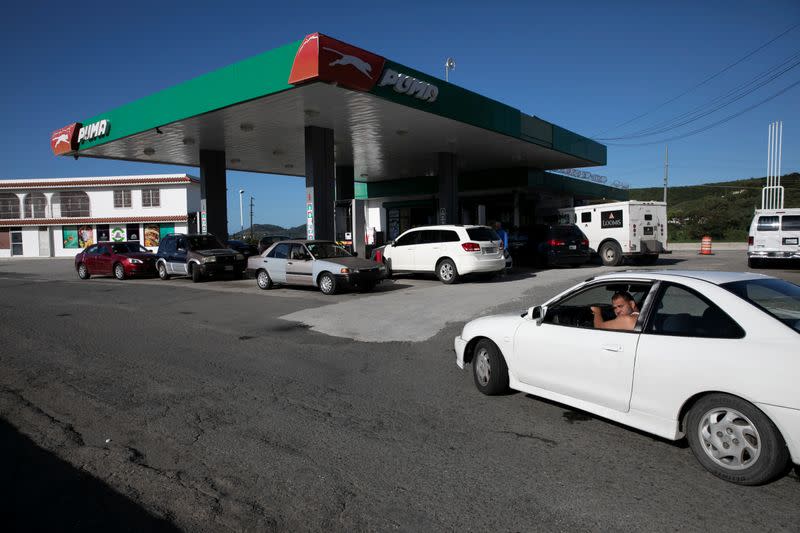 Cars queue for fuel at a gas station after an earthquake in Guanica